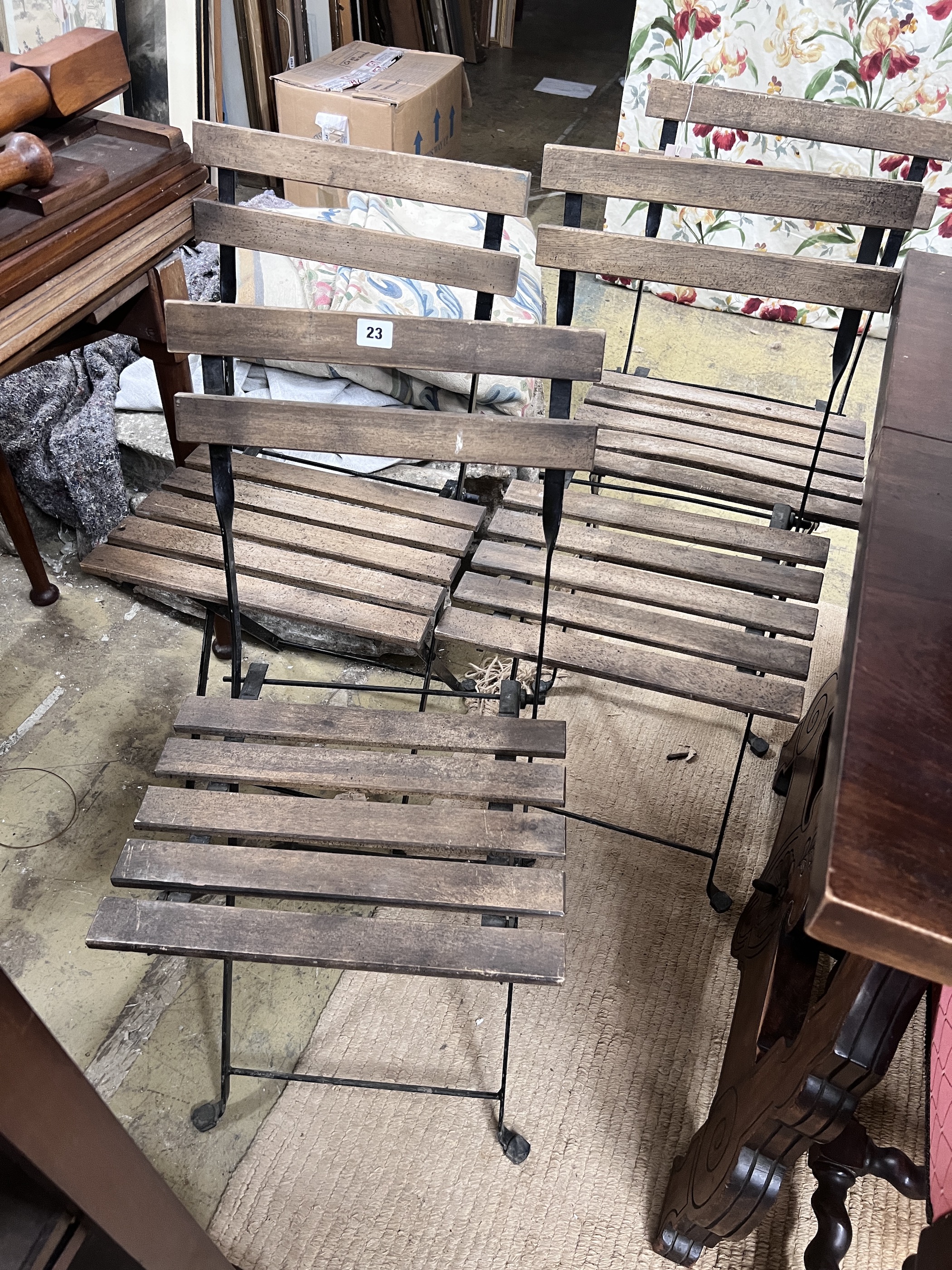 A set of four wrought iron slatted wood folding garden chairs